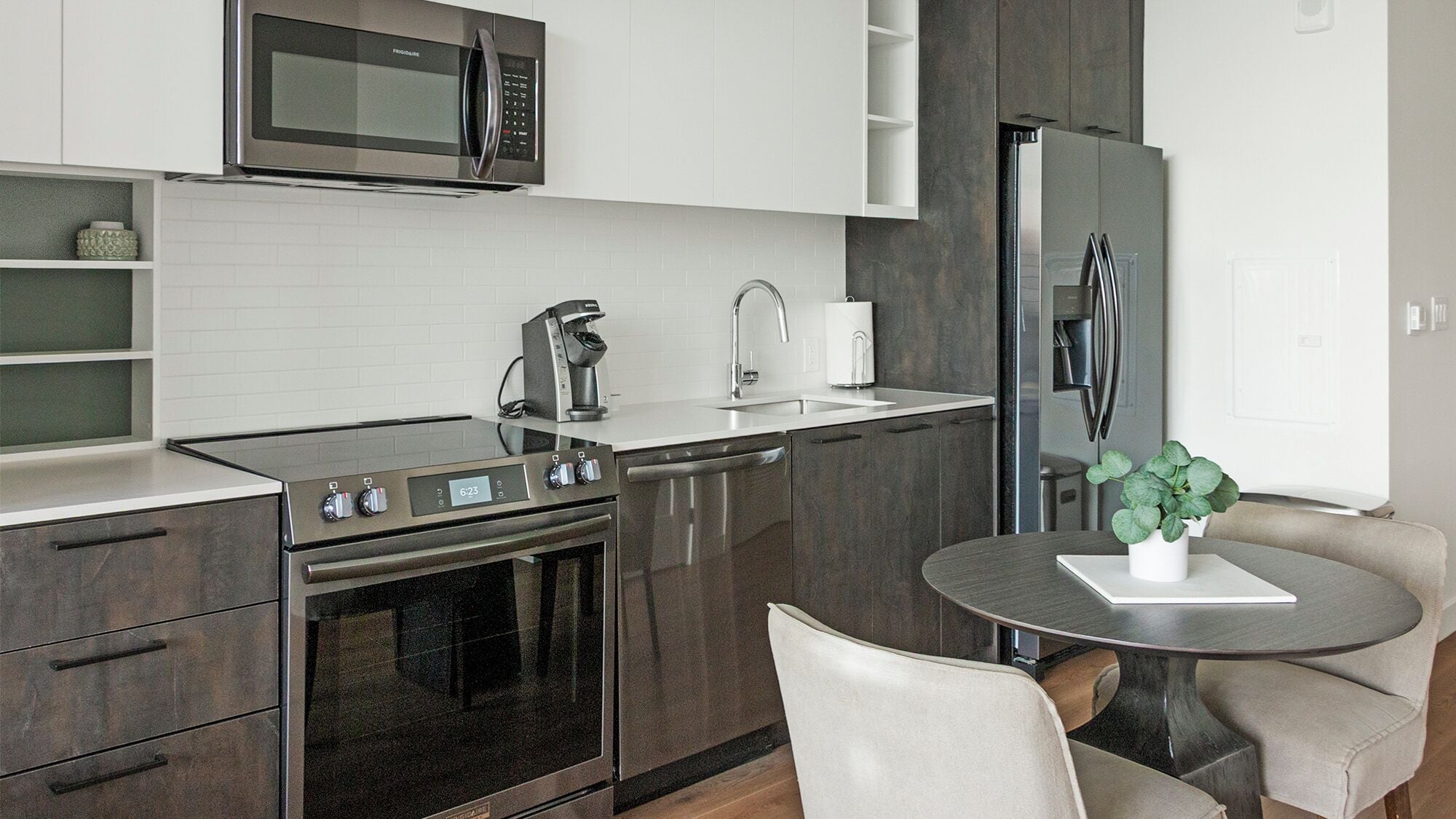 Een koelkast met diepvriezer, een microgolfoven, een oven, een kookplaat