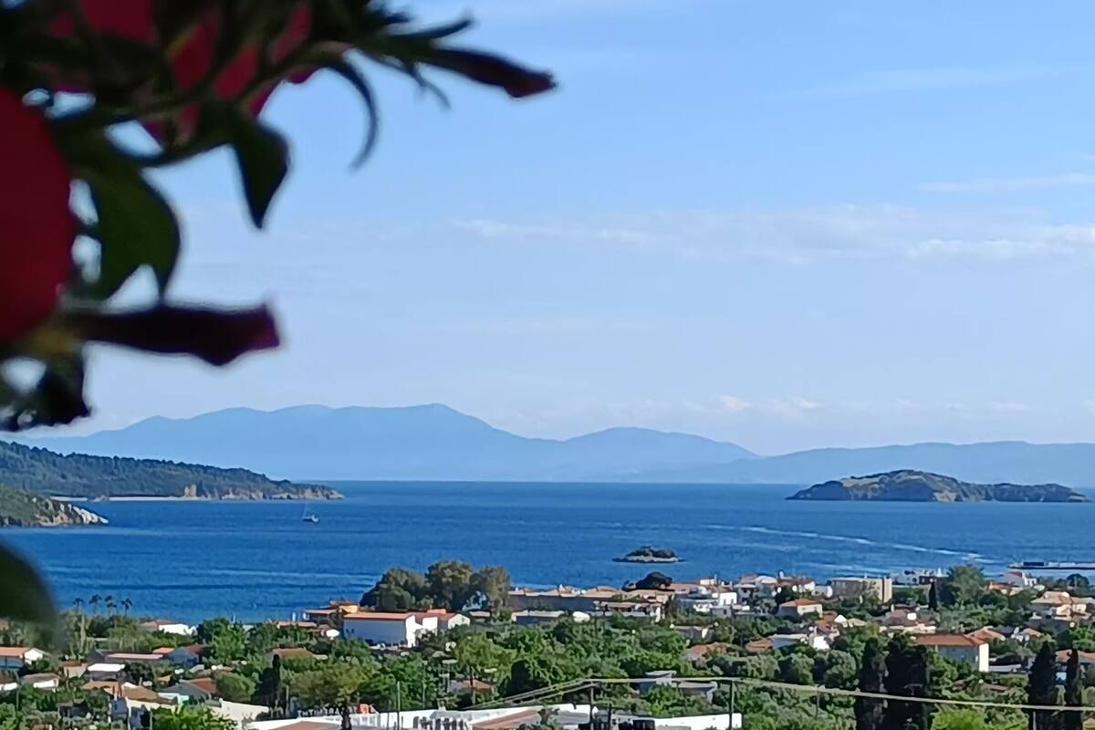 A coastal town with a view of the sea and distant mountains.