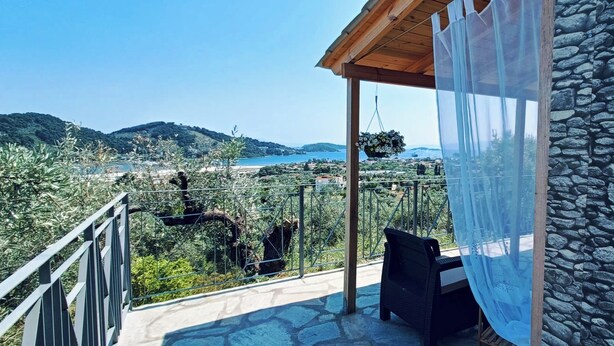 Ein Balkon mit Steinmauer und Blick auf eine Küstenlandschaft.