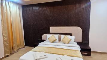 A modern bedroom with a large bed, a ceiling fan, and a dark wooden headboard.
