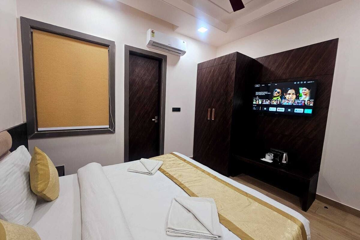 Une chambre d’hôtel équipée d’un lit, d’une télévision, d’une armoire et d’un appareil de climatisation.