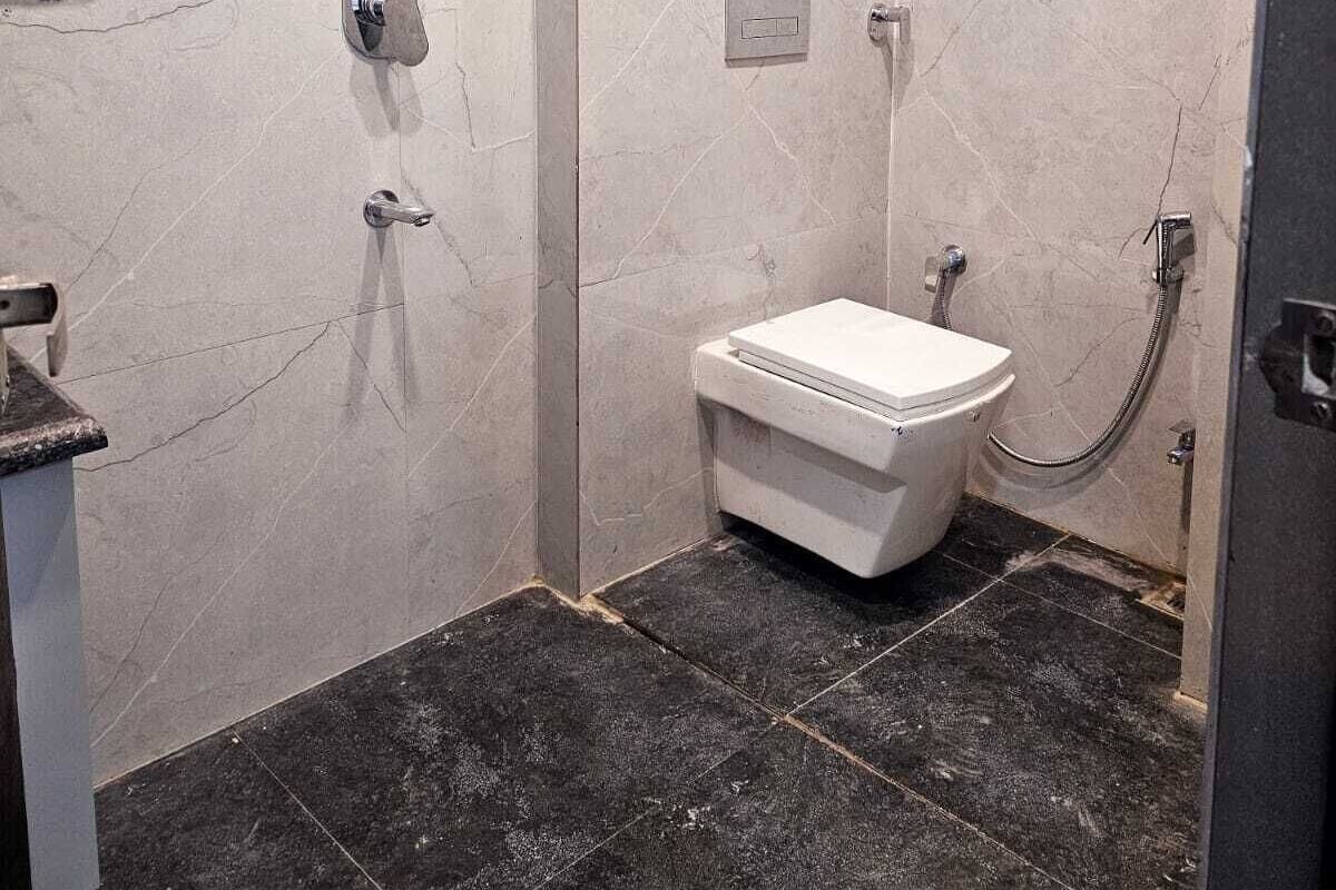 Une salle de bain moderne avec douche, toilettes et un mur en marbre.