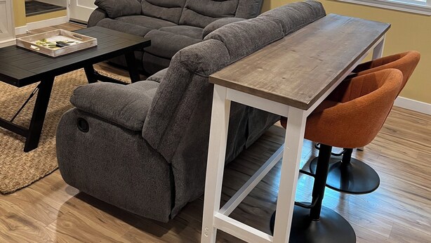 A living room with a gray sectional sofa, a wooden coffee table, and an orange chair. - Sequim Getaway (Sequim)