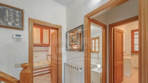 A hallway with a wooden staircase, a radiator, and a bathroom visible through an open door. - IL BORGHETTO - VILLINO IL BORGHETTO (Campo nell'Elba)