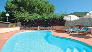 A swimming pool with blue water, surrounded by lounge chairs and a wooden fence. - Appartamenti Arcipelago - Appartamenti Arcipelago - Bilocale (30) (Rio dell'Elba)
