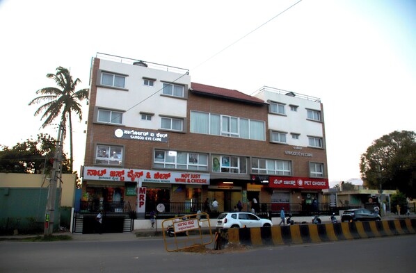 A multi-story building with various shops on the ground floor, including a pet care store. - HUNKAL STAYS (Chikkamagaluru)