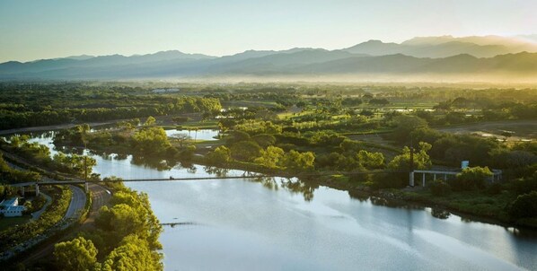 Un río rodeado de vegetación y un puente.