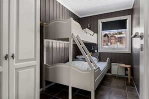 A bunk bed with a ladder, a window with a view, a small stool, and a door with a handle. - Ski-in/Ski-out apartment with Sauna in Trysil REF:TH720 (Trysil)