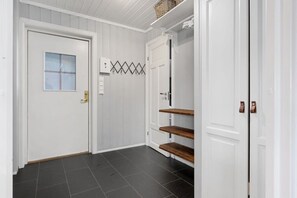 A hallway with a white door, a window, and a wall-mounted light switch. - TH720 Ski-in/Ski-out apartment with Sauna in Trysil (Trysil)