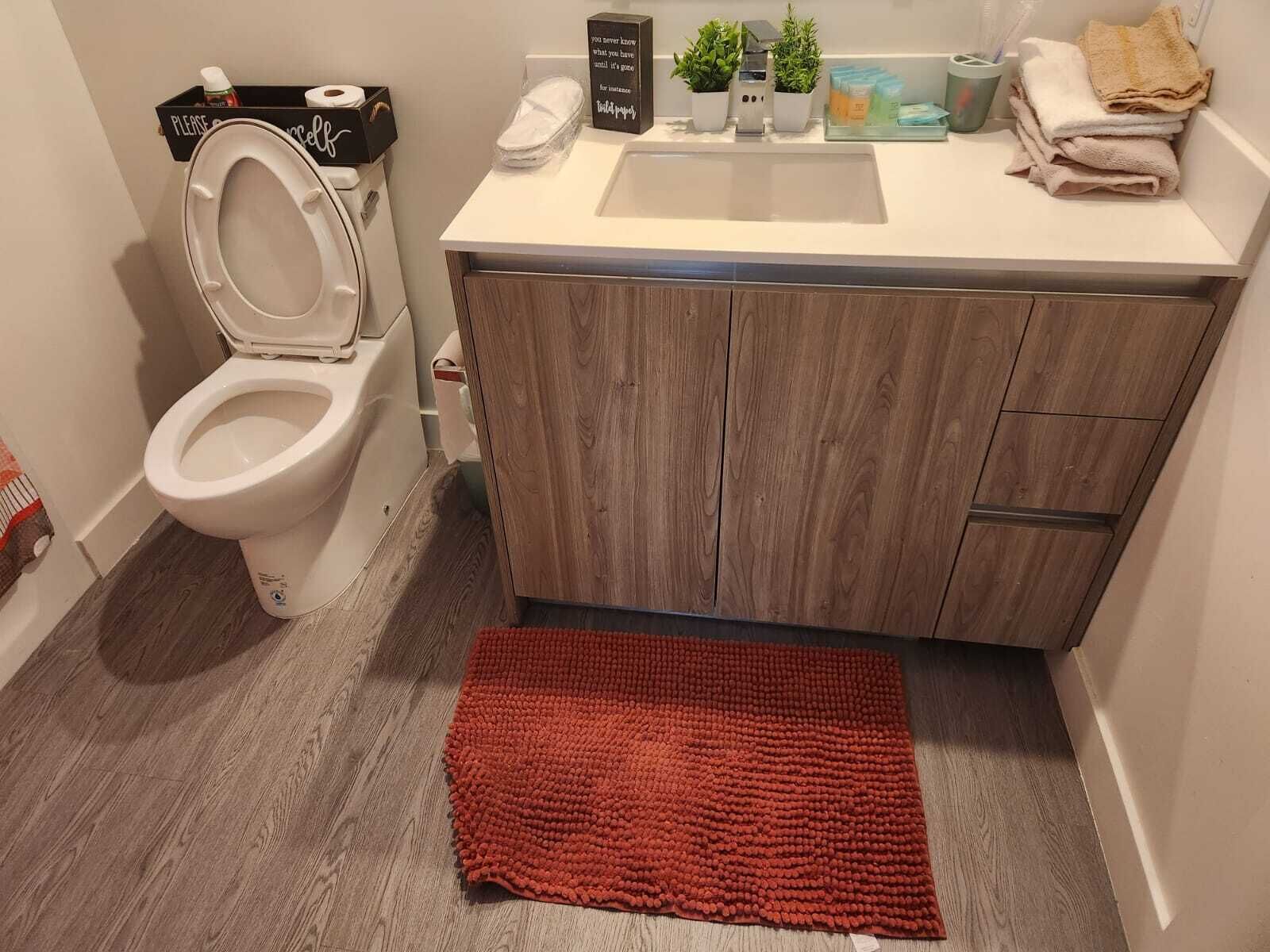 Ein Badezimmer mit Toilette, Waschbecken und Holzschränken.
