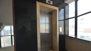 An elevator in a modern building with a digital display showing the number 3. - Coastal Grand - COIMBATORE (Coimbatore)