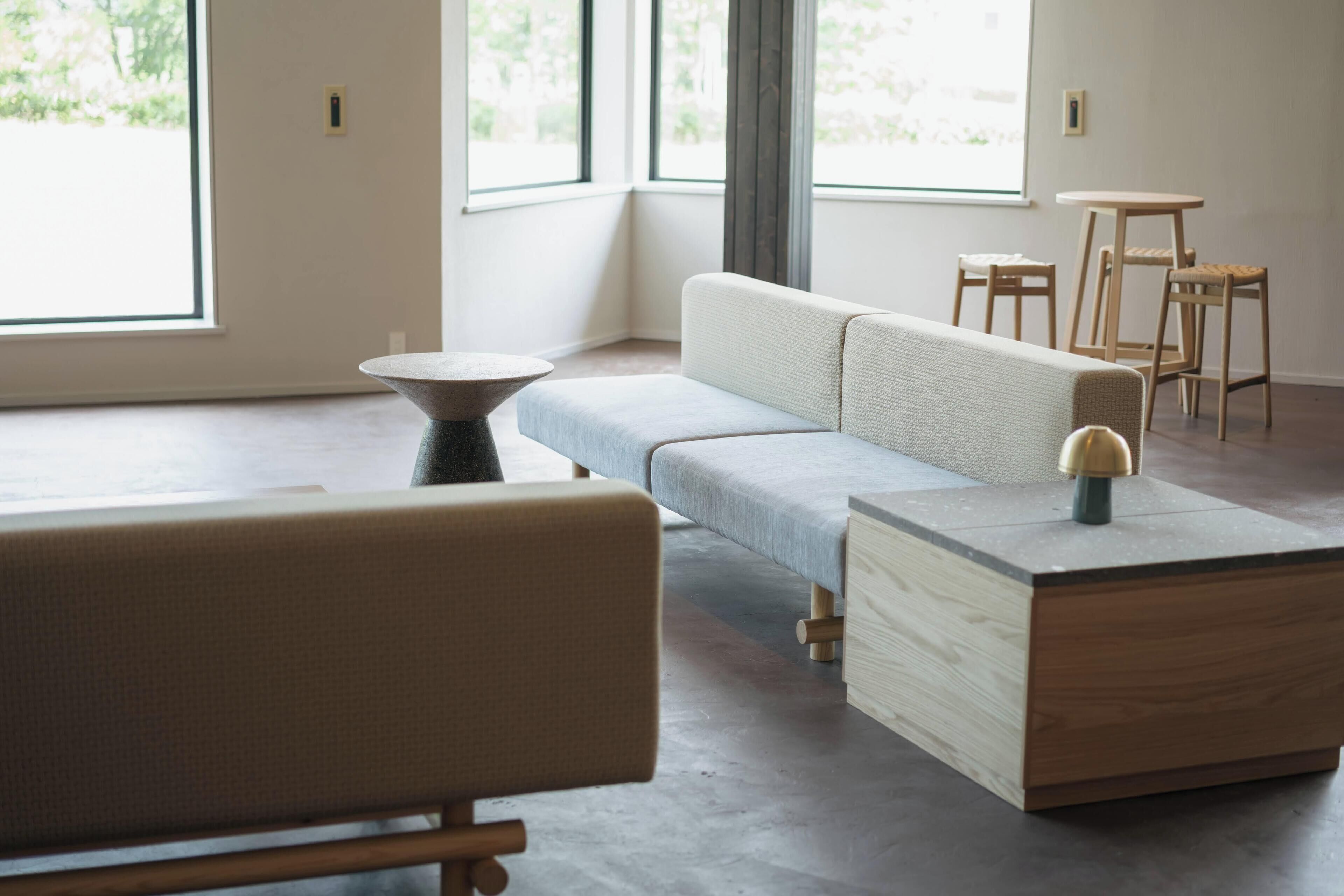 Un salon moderne avec un canapé, une table basse et une petite table d’appoint en bois.