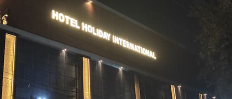 A building with a sign that reads "HOTEL HOLIDAY INTERNATIONAL".