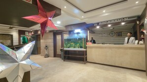 A reception area with a reception desk, a large fish tank, and a decorative star hanging from the ceiling. - Hotel Holiday international (Purnia)
