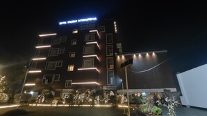 A multi-story hotel building with illuminated signage reading "HOTEL HOLIDAY INTERNATIONAL." - Hotel Holiday international (Purnia)