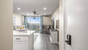 Una cocina moderna con zona de comedor, ventilador de techo y vista a través del ventanal.