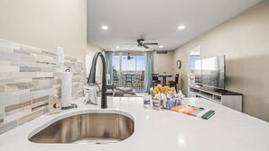 Una cocina moderna con un lavamanos grande, un ventilador de techo y vistas al exterior.