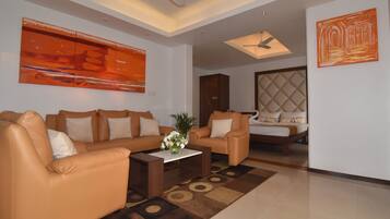 A modern living room with a sofa set, a coffee table with a floral centerpiece, and a decorative rug.