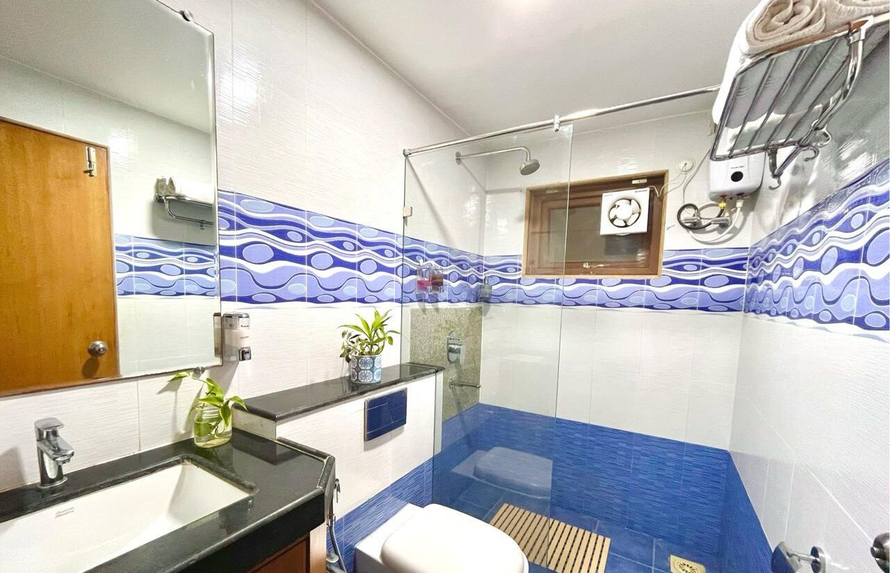 A bathroom with a sink, toilet, and shower area.