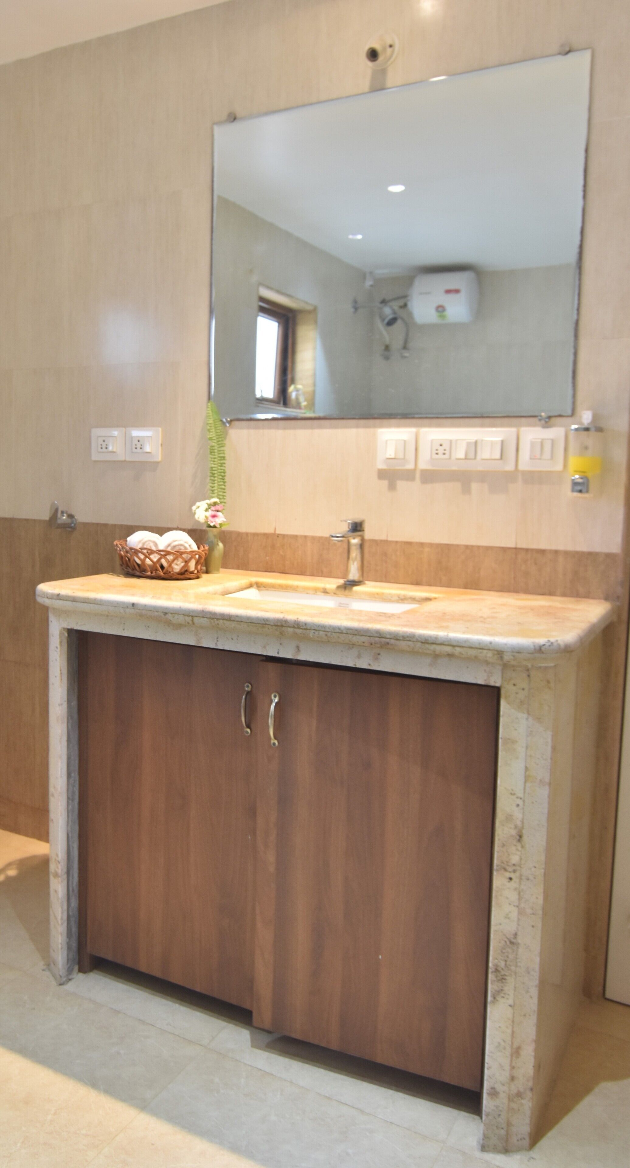 A bathroom with a wooden vanity, a sink, and a mirror.