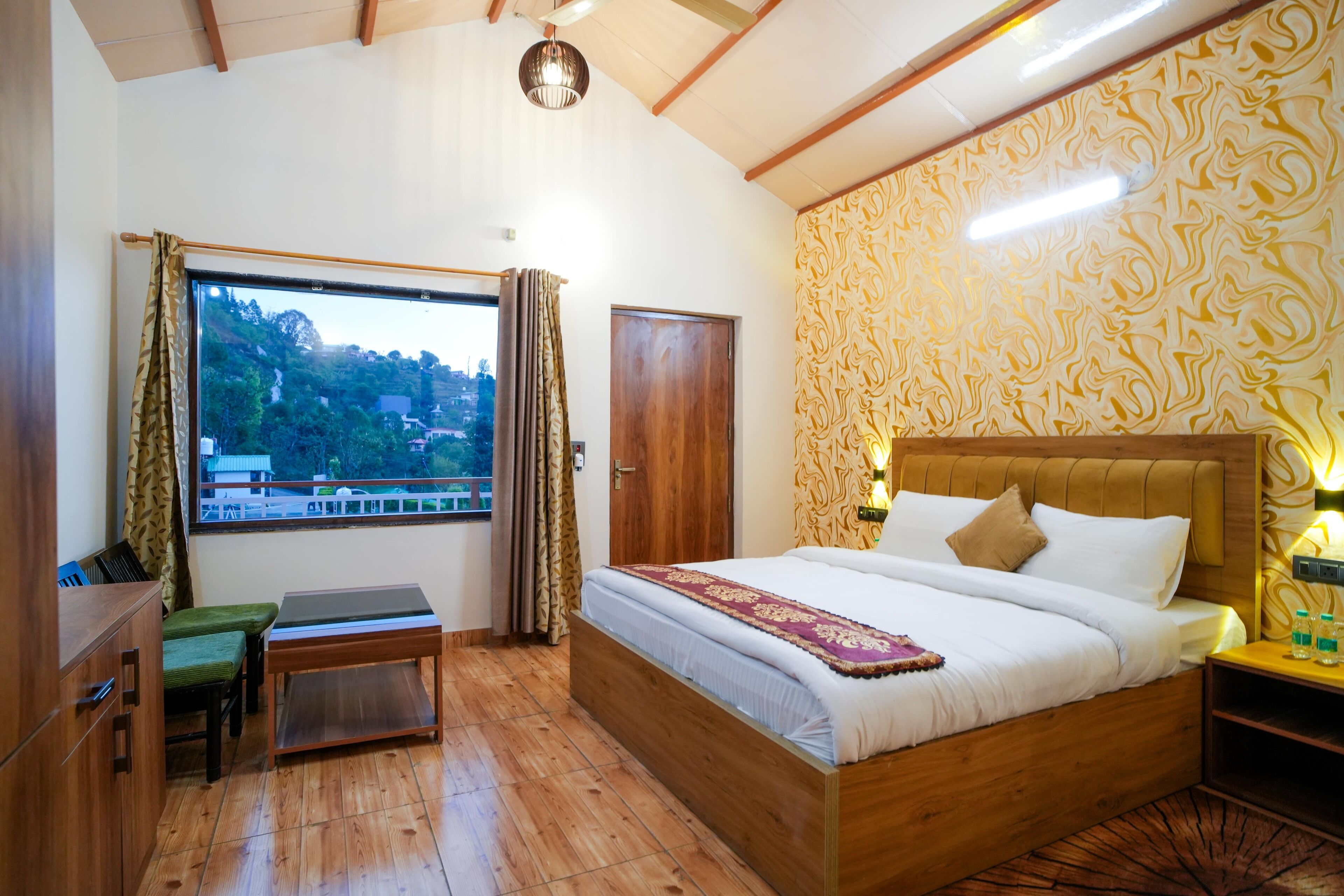 A bedroom with a wooden bed, a desk, and a view of a hillside.