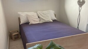 Une chambre à coucher avec un lit, une fenêtre et une plante en pot.
