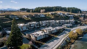 Un complejo residencial con varios edificios de apartamentos, un estacionamiento y una calle.