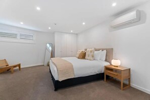 Un dormitorio con cama, mesita de noche y espejo.