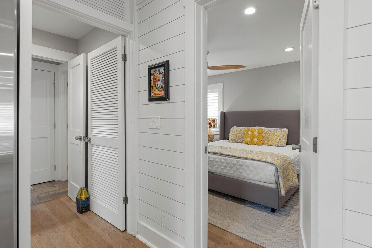 A bedroom with a bed, a bedside table, a nightstand, and a wall-mounted picture.