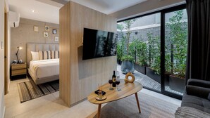 Une chambre à coucher moderne avec un lit, une table de chevet et un téléviseur fixé au mur.