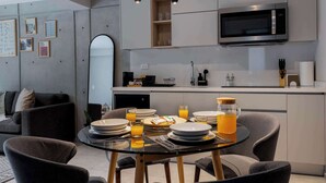 A modern kitchen with a dining area, a microwave, and a coffee maker. - Capitalia | Your Sky-High Sanctuary in Condesa (Ciudad de México)