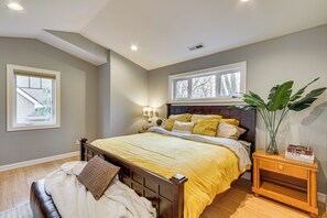 Une chambre à coucher avec un lit, une table de chevet, une lampe et une fenêtre.