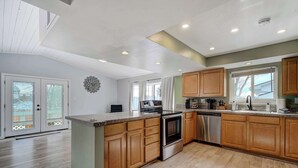 Una cocina moderna con armarios de madera, electrodomésticos de acero inoxidable y una isla grande.