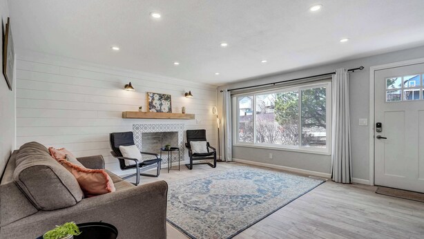 Un salón amplio con chimenea, un ventanal grande y una puerta corrediza.