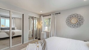 Un dormitorio moderno con una cama grande, un espejo y un adorno en la pared.