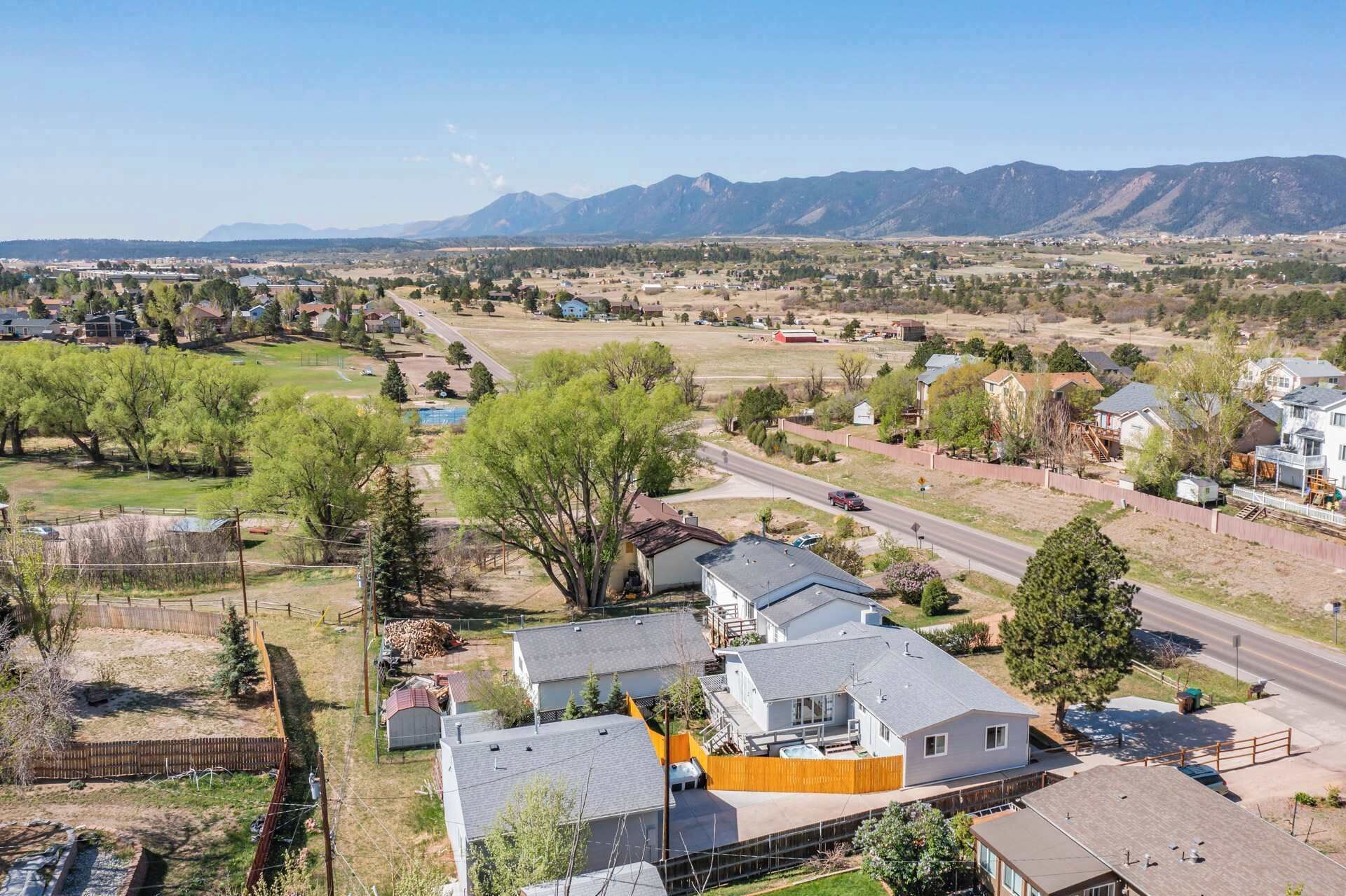 Un barrio residencial con casas, una carretera y montañas al fondo.