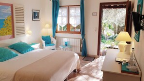 A bedroom with a bed, a chair, a table, a window, and a view of the outdoors. - le Mas des Cigales (Tourrettes-sur-Loup)