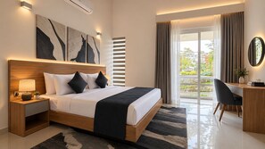 Une chambre d’hôtel moderne avec un grand lit, une table de chevet, une lampe et une œuvre d’art.