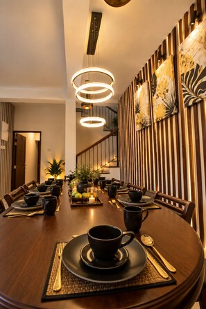 A dining area with a round table set for a meal, featuring black tableware and a central candle. - Lake Villas Premium Kandy (Kandy)