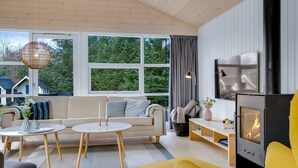 Un salon moderne avec un canapé, un fauteuil jaune et une cheminée.