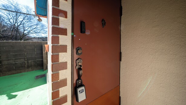 Uma porta com fechadura eletrônica, caixa de correio e abertura para correspondência.