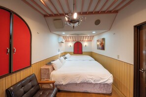 A hotel room with a large bed, a red door, a wooden bench, and a ceiling fan. - Grand Hotel Narita Airport (Narita)