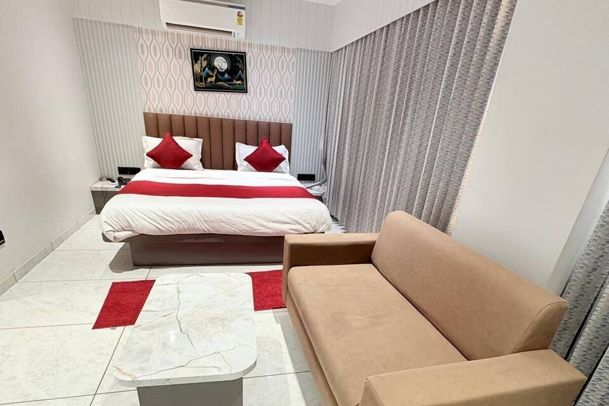Un dormitorio moderno con cama, sofá, mesa de centro y ventilador de techo.