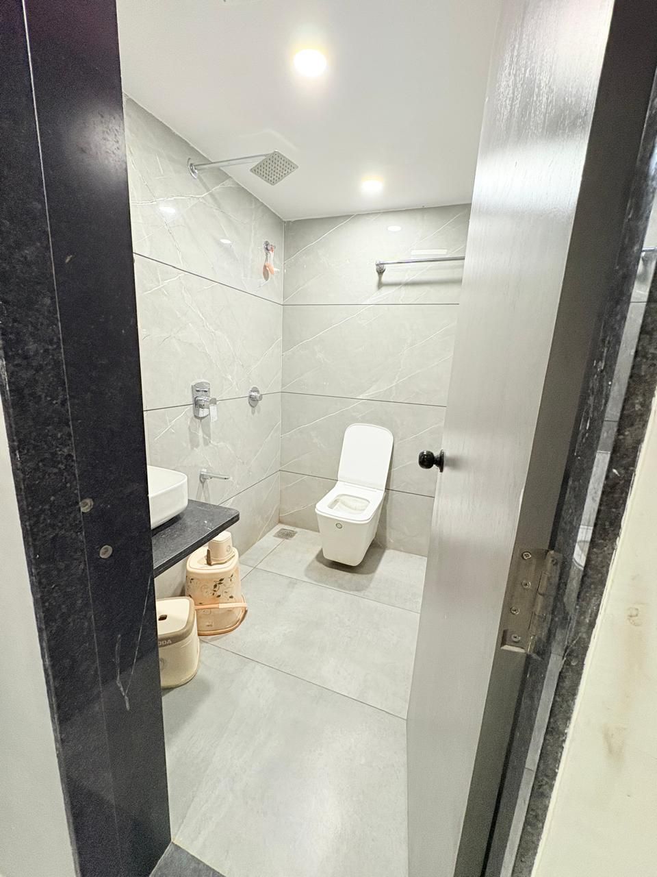 A modern bathroom with a toilet, sink, and shower.