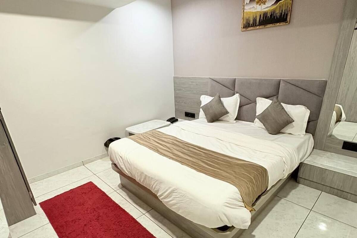 Un dormitorio moderno con una cama grande, un tapete rojo y un cuadro en la pared.