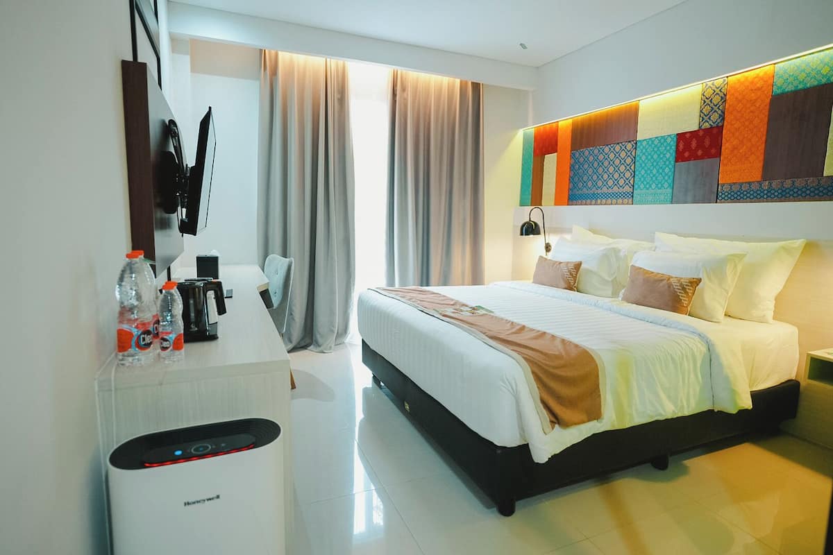 Ein modernes Hotelzimmer mit Bett, Nachttisch und Schreibtisch mit Heizung.