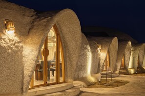 A series of igloo-like structures with interior lighting and a stone pathway. - PRAVEG CAVES JAWAI (Bali)