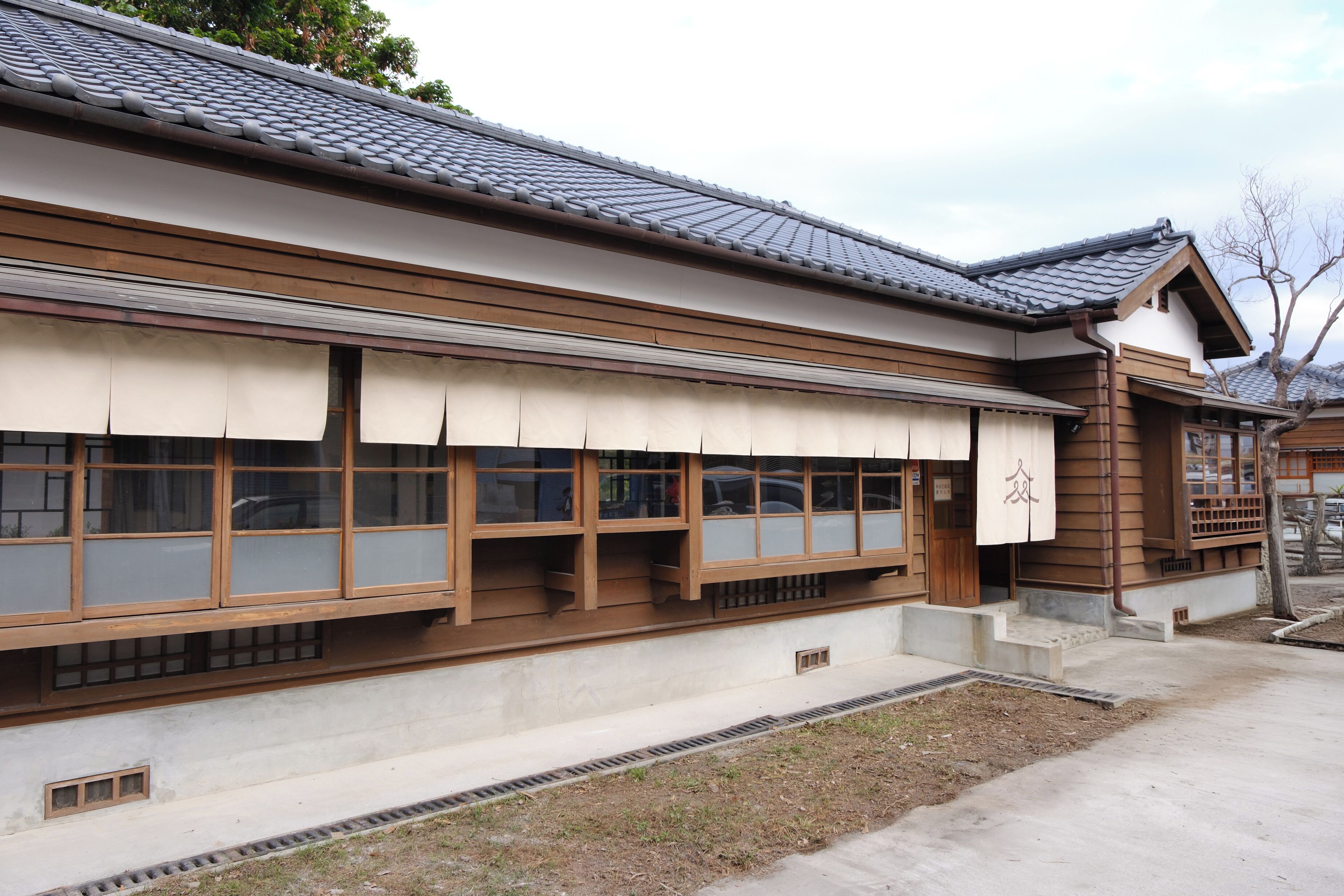 Un edificio japonés tradicional con techo de tejas, vigas de madera y puertas correderas.