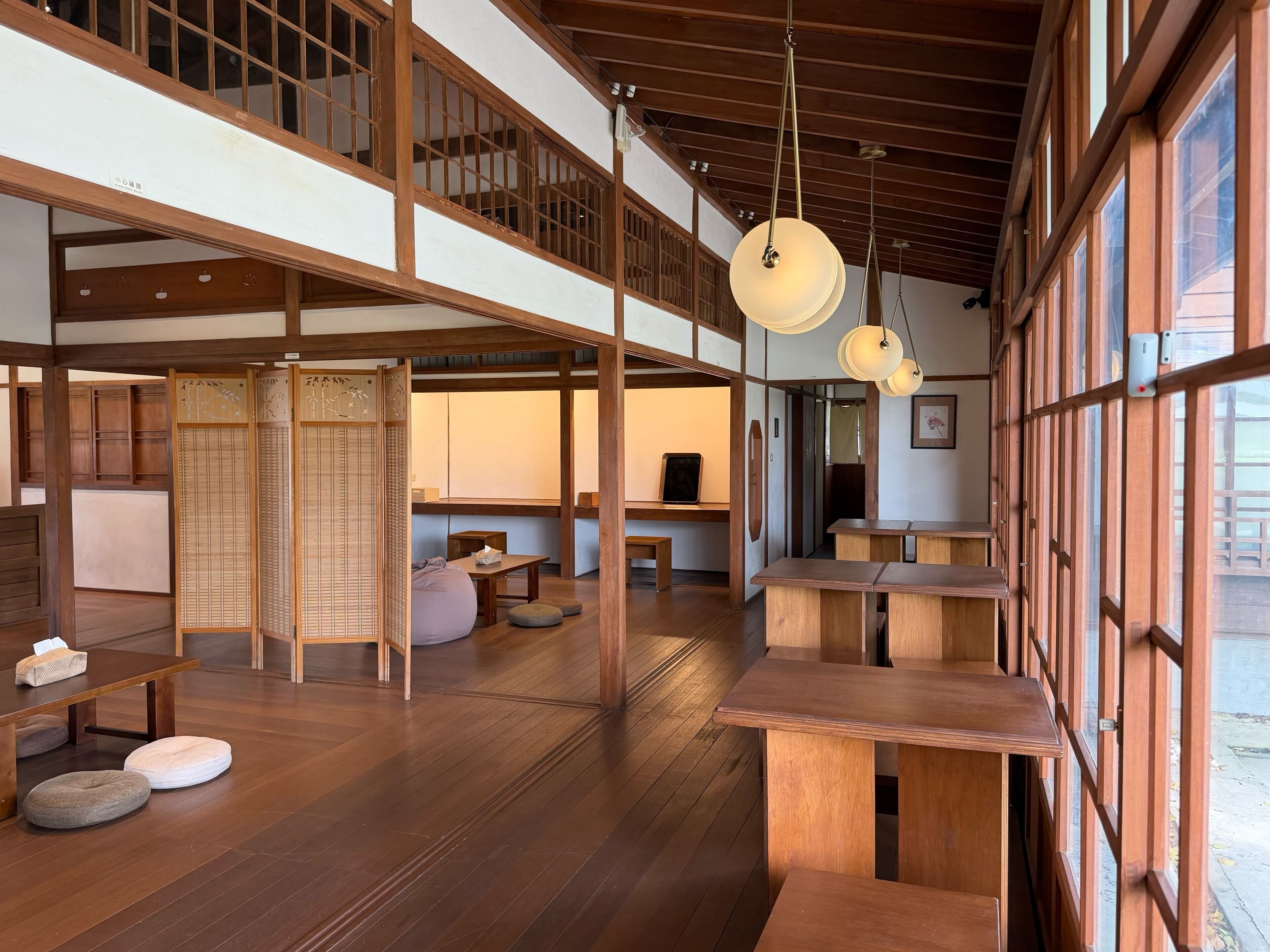 Un intérieur japonais traditionnel avec un sol recouvert de tatamis, des meubles en bois et des portes coulissantes.