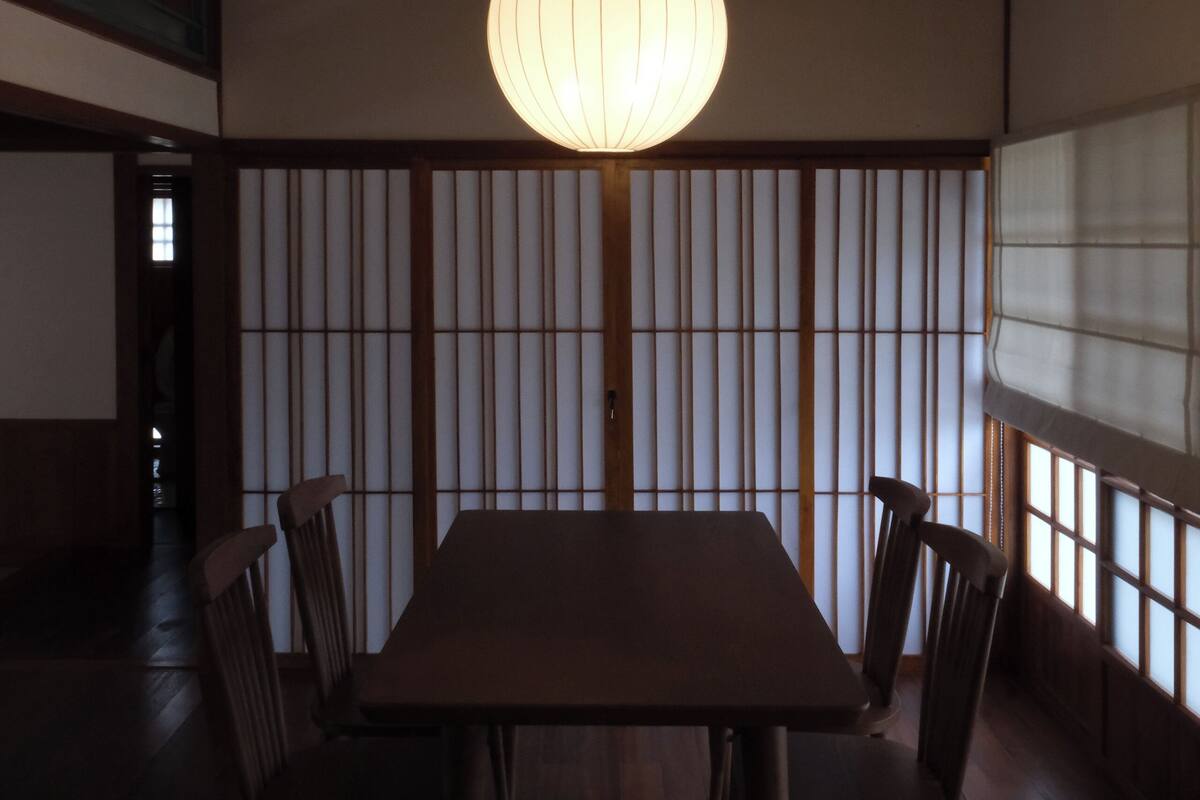 A traditional Japanese-style room with tatami flooring, a low table, and shoji screens.